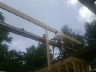 Carpenter setting a ridge beam over a new addition frame — Ice Dam Removal by Roofing Brothers in Filley