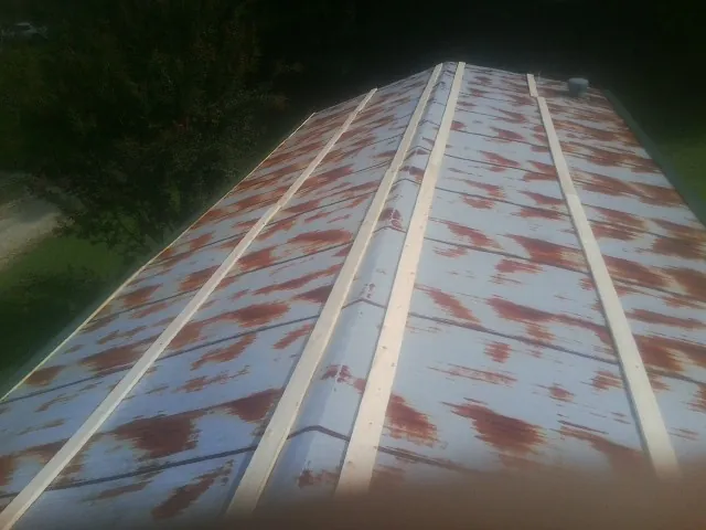 Rusted metal roof panels with new wood purlins before replacement — Storm Damage Roof Repair in Filley by Roofing Brothers