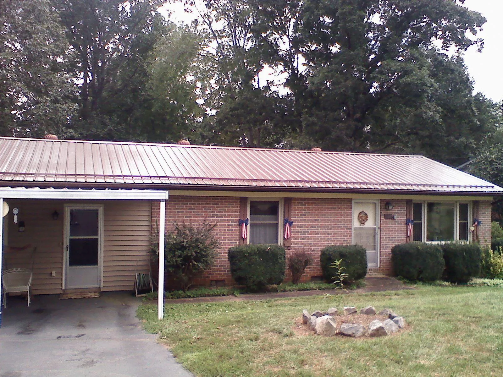 Bronze metal roof and carport on a brick ranch home — Roof Repair work by our crew in Filley
