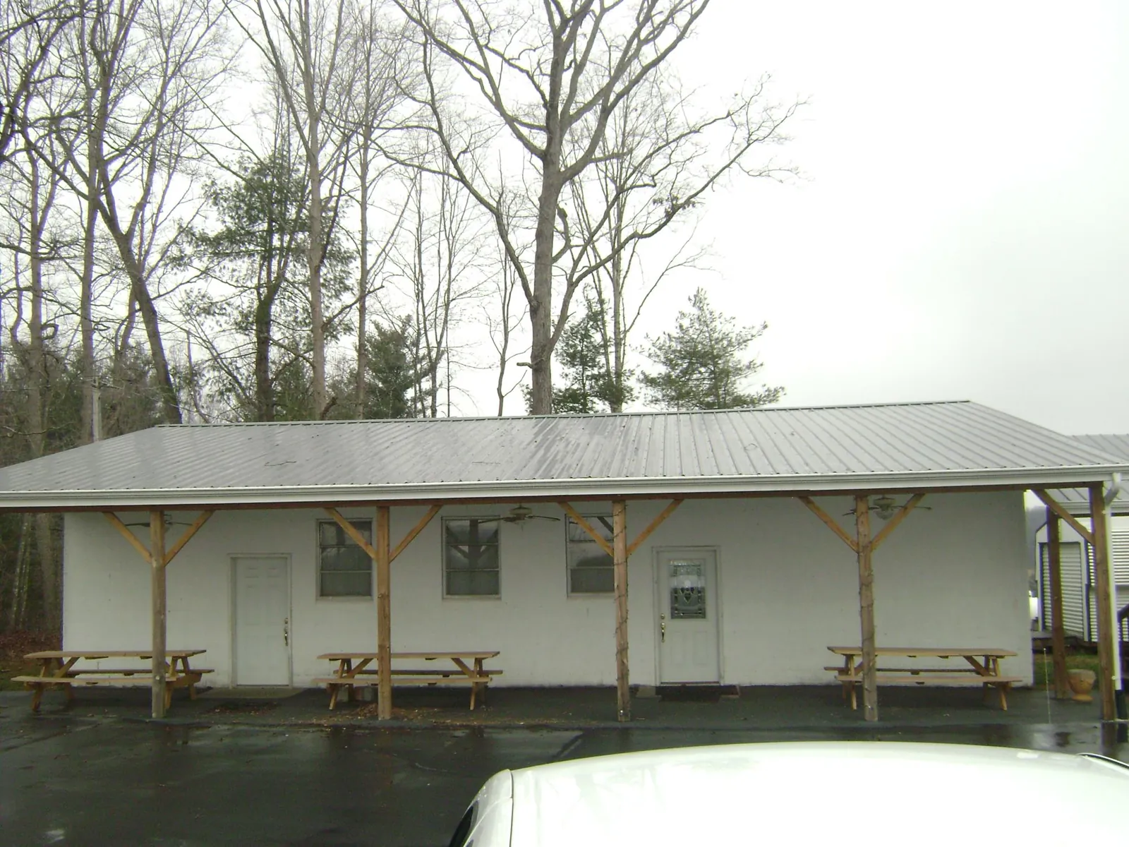 Gray metal roof over a block building with a timber post porch in Filley